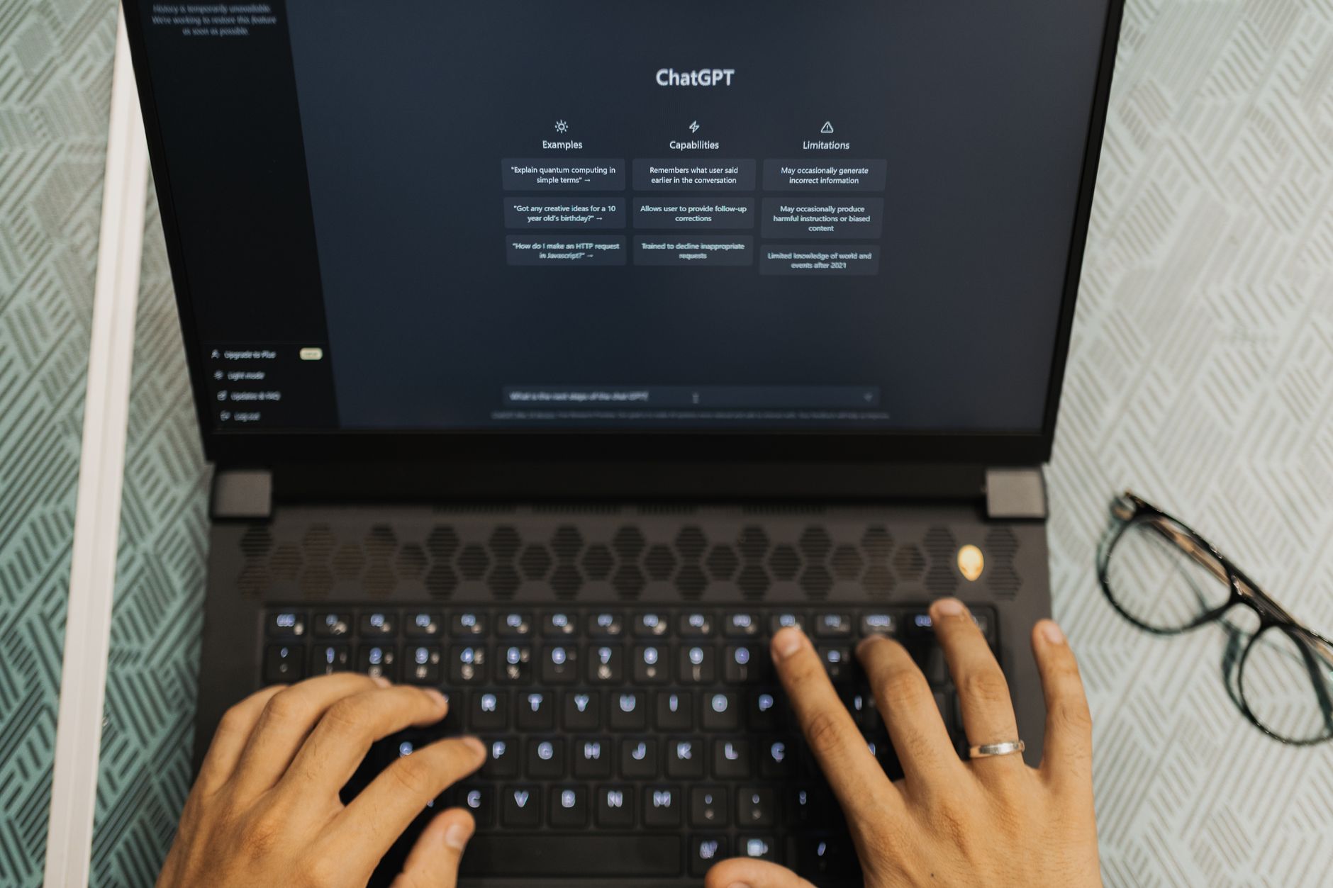 自然光が差すオフィスデスク、ChatGPT検索表示される方法が映るPCと観葉植物