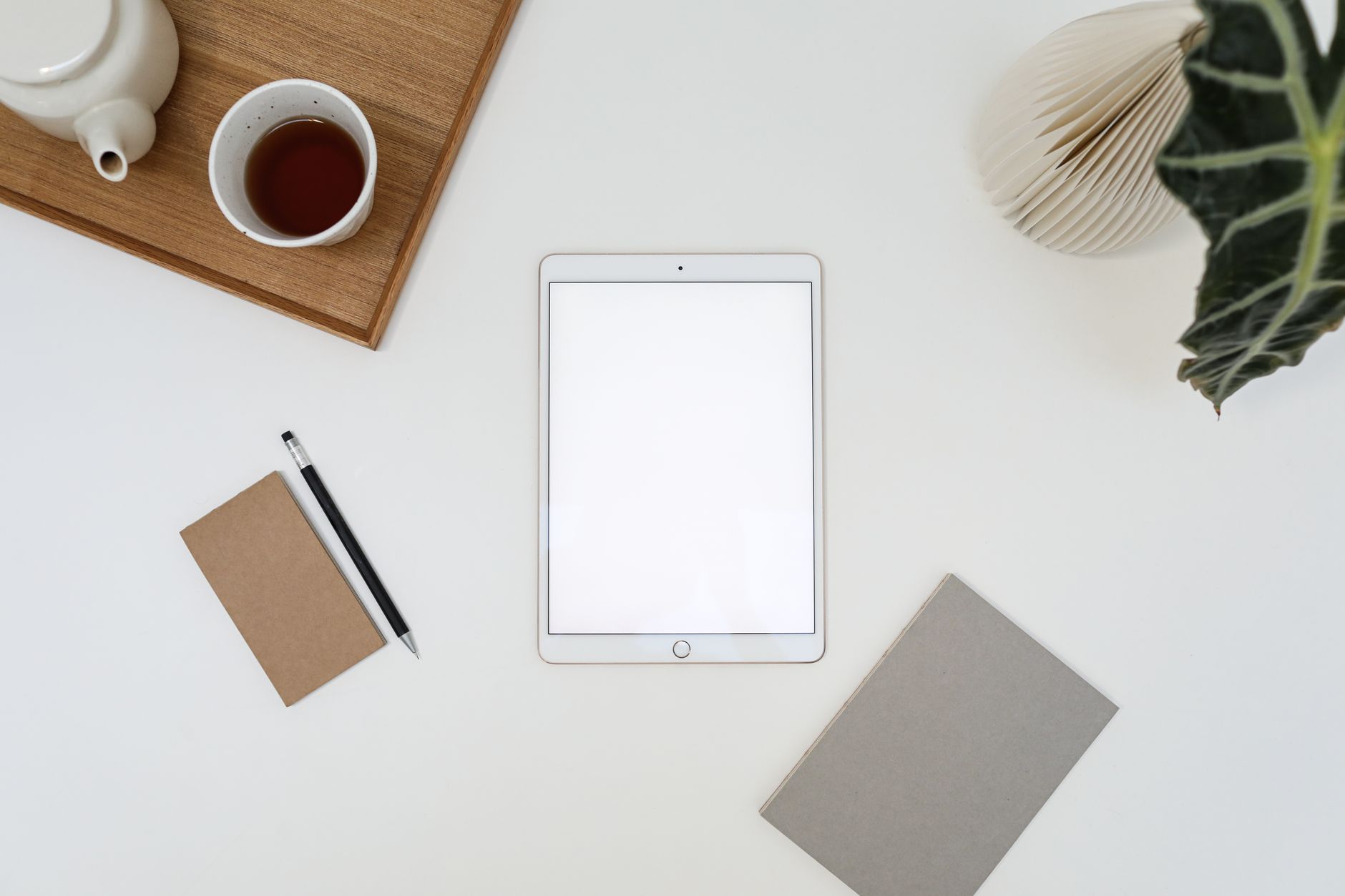 動画マニュアル 作成に使うタブレットと観葉植物が置かれたオフィスのデスク